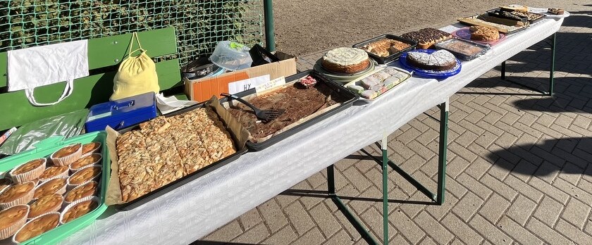 Kuchen und Muffins auf einem langen Tisch auf dem Schulhof