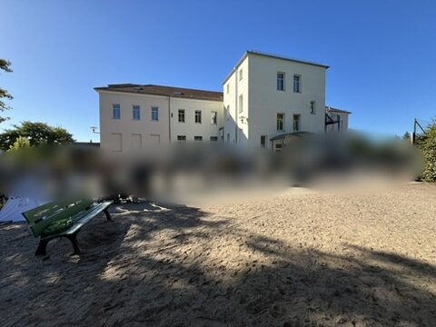 Schulhof vor dem Schulgebäude, Personen unkenntlich